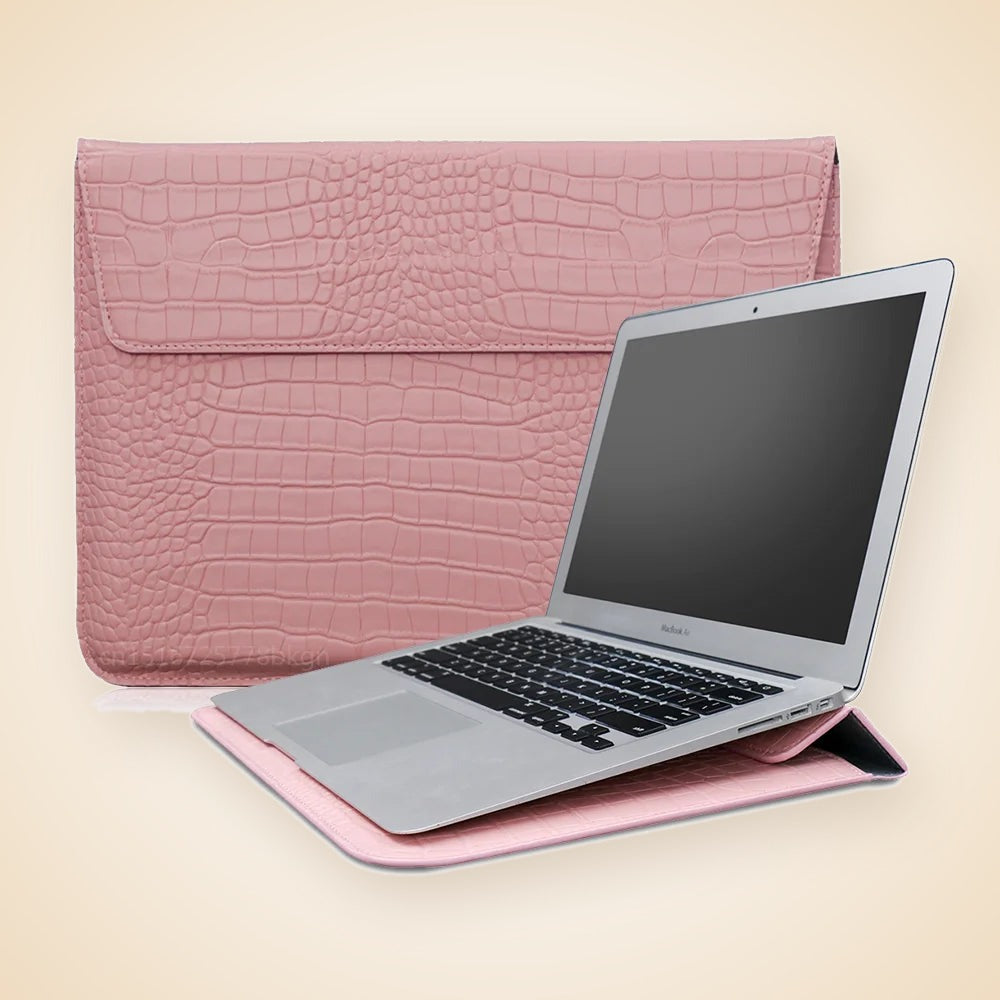 Rosa fodral med krokomönster bredvid en laptop